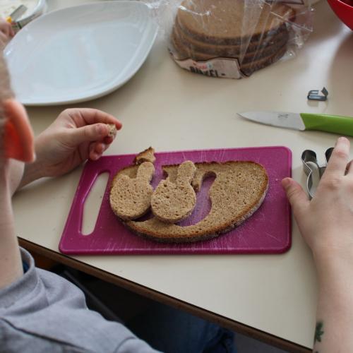 Kind mit Brot, Messer, Brett, Ausstechform