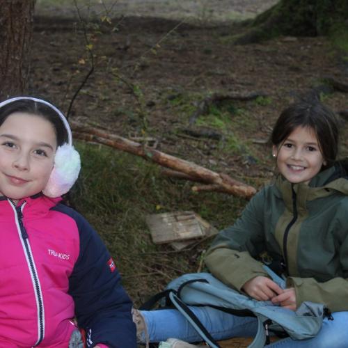 2 Mädchen sitzen im Wald