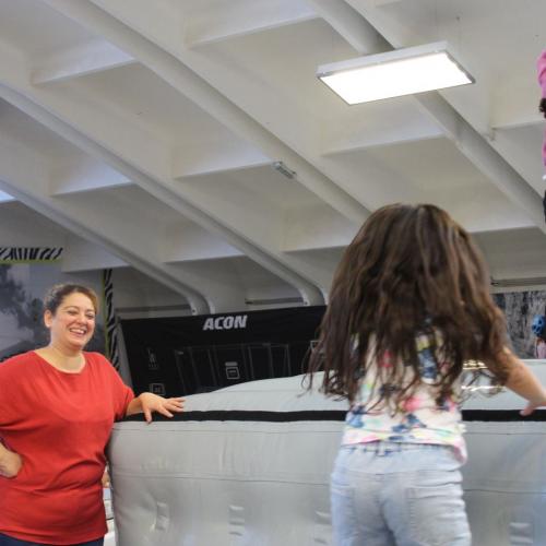 zwei Kinder hüpfen eine Betreuerin lächelt 