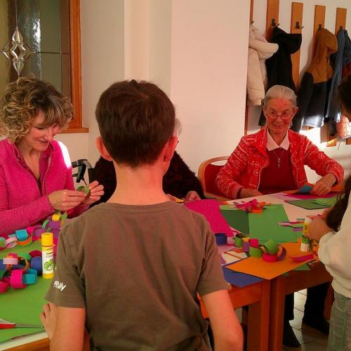 Kinder von hinten und Senioren beim Basteln