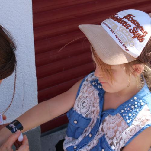 Mädchen bekommt ein Glitzertatto auf den Arm 