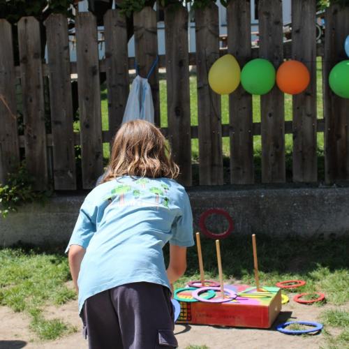 Mädchen schießt Ring auf einen Stab- Spielefest