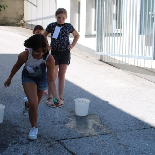 Mädchen läuft mit einem Schwamm- transportiert Wasser