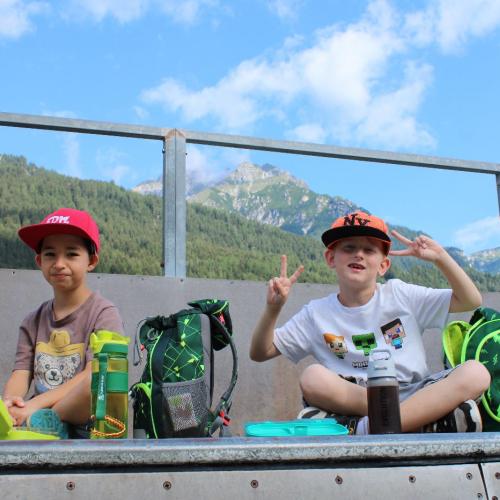 2 Jungs sitzen oben auf einer Rampe 
