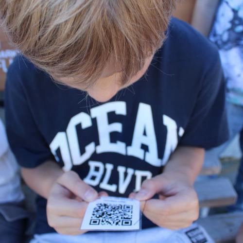 Kind hält einen QR Code in der Hand 