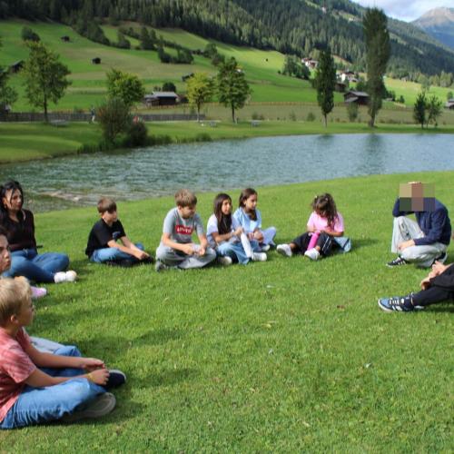Kinder sitzen im Kreis in der Wiese