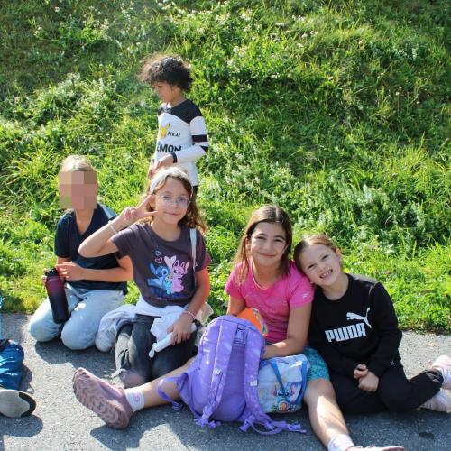 Mädchen sitzen am Boden und Jausnen