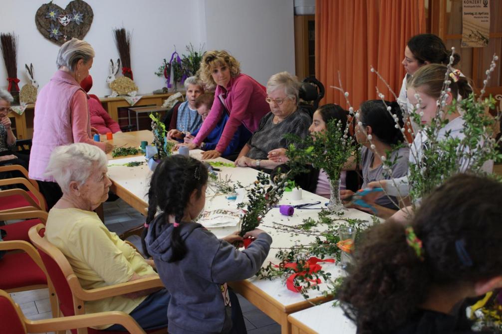 Senioren und Kinder binden Sträuße 