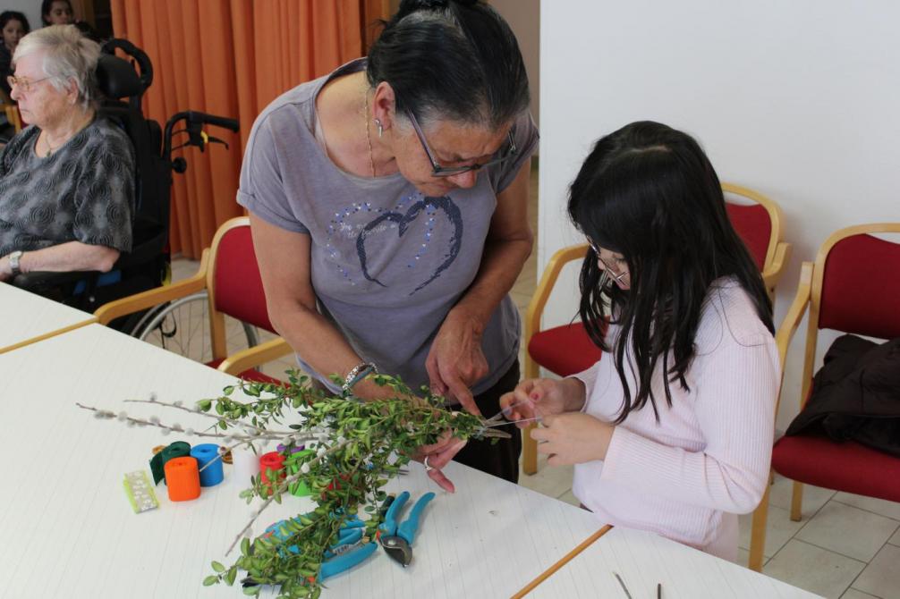 Mädchen und Seniorin beim Binden 
