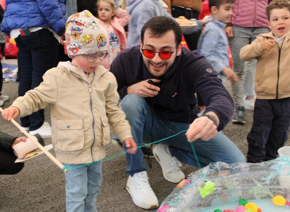 Kind mit einem Betreuer beim Fische angeln 