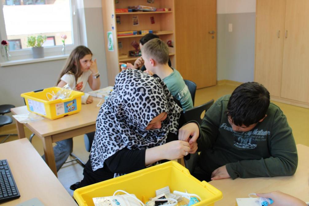 Zwei Kinder und eine Betreuerin beim Bauen 