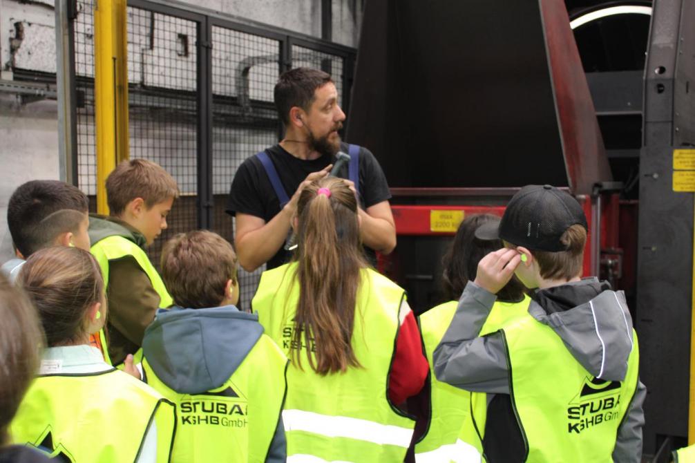Mitarbeiter zeigt den Kindern die Arbeitsprozesse 