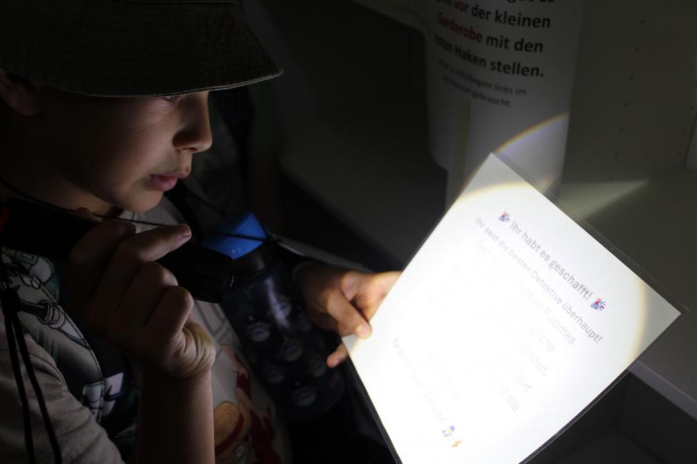 Kind mit taschenlampe und hinweis 