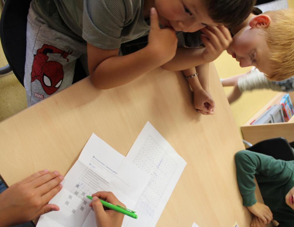 Kinder lösen ein Kreuzworträtsel 