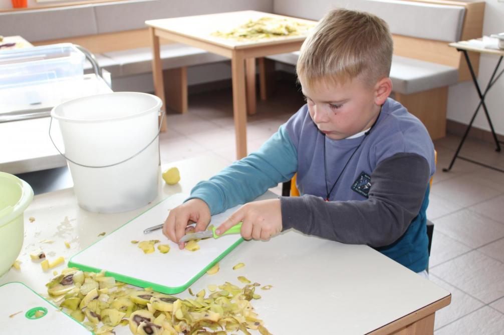 Kind schneidet eine Kartoffel 