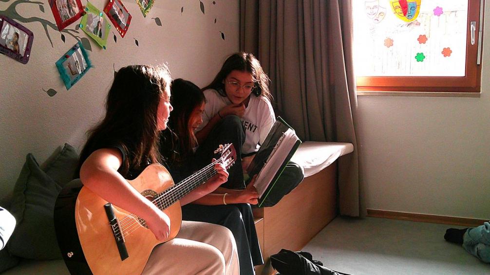 Mädchen spielt mit der Gitarre, 2 Mädchen singen 