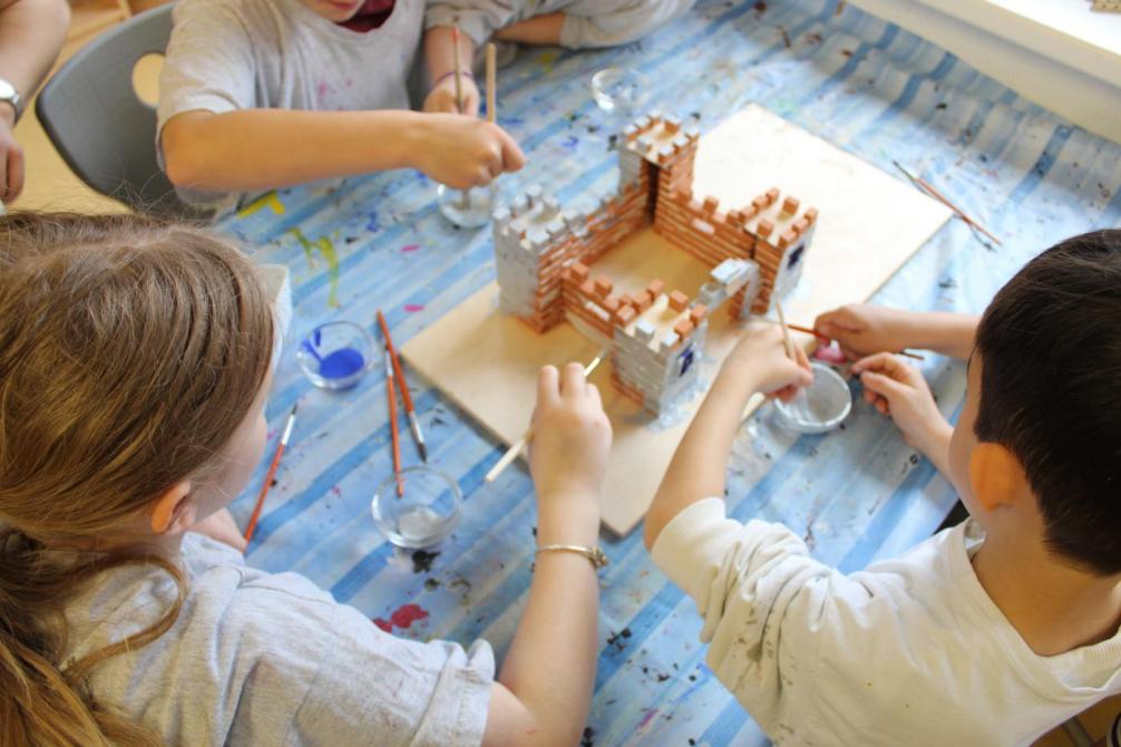 Kinder bemalen eine Burg 