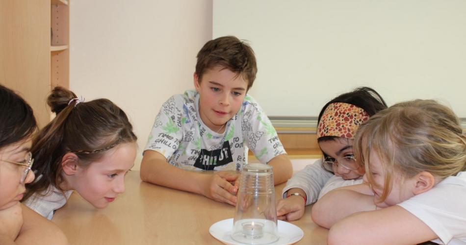 5 beobachtende Kinder, 1 Teelicht, 1 Glas 