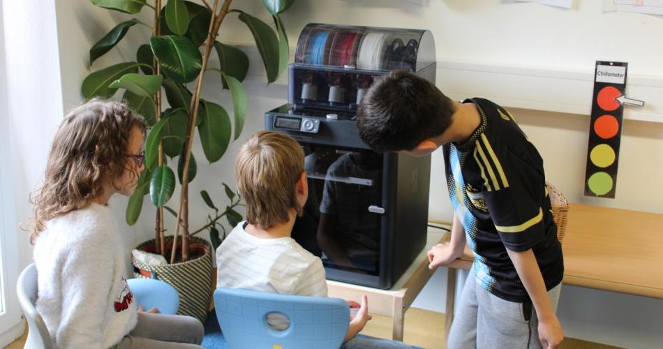 3 Kinder beobachten den 3D-Drucker