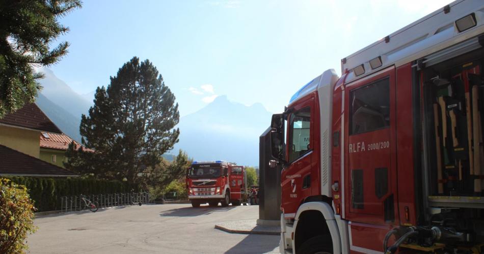 Zwei Feuerwehr Autos stehen auf dem Schulgelände 