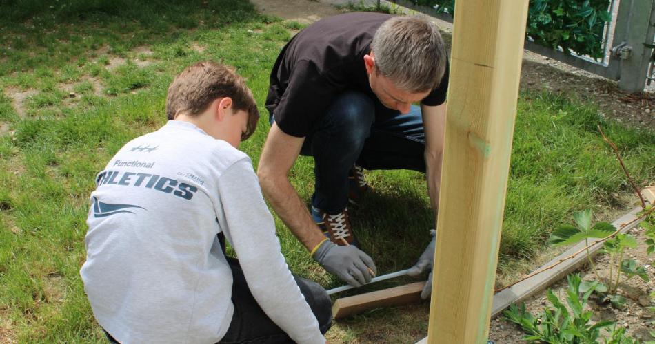 Kind baut mit Mann im Garten