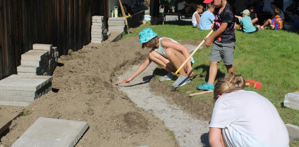 Kinder helfen beim gestalten des Barfußweges