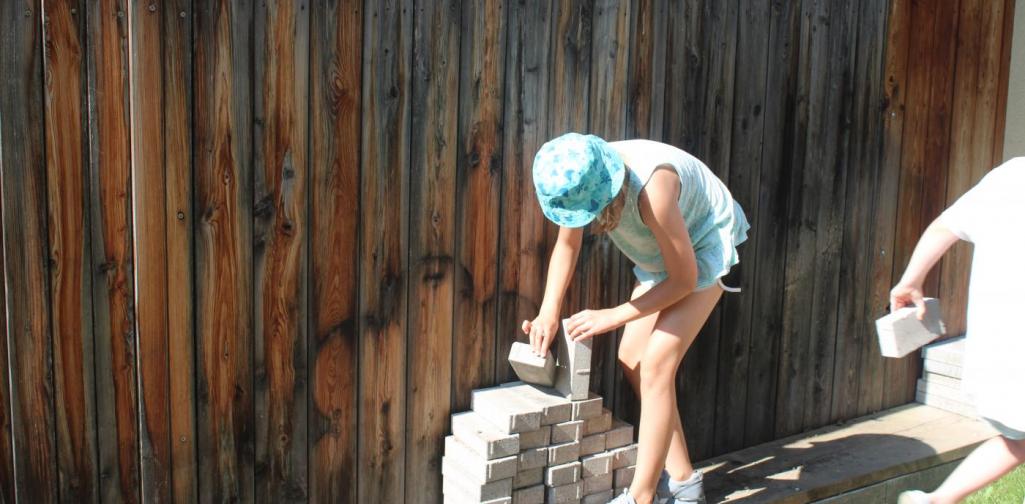 Kinder tragen Steine für den Barfußweg