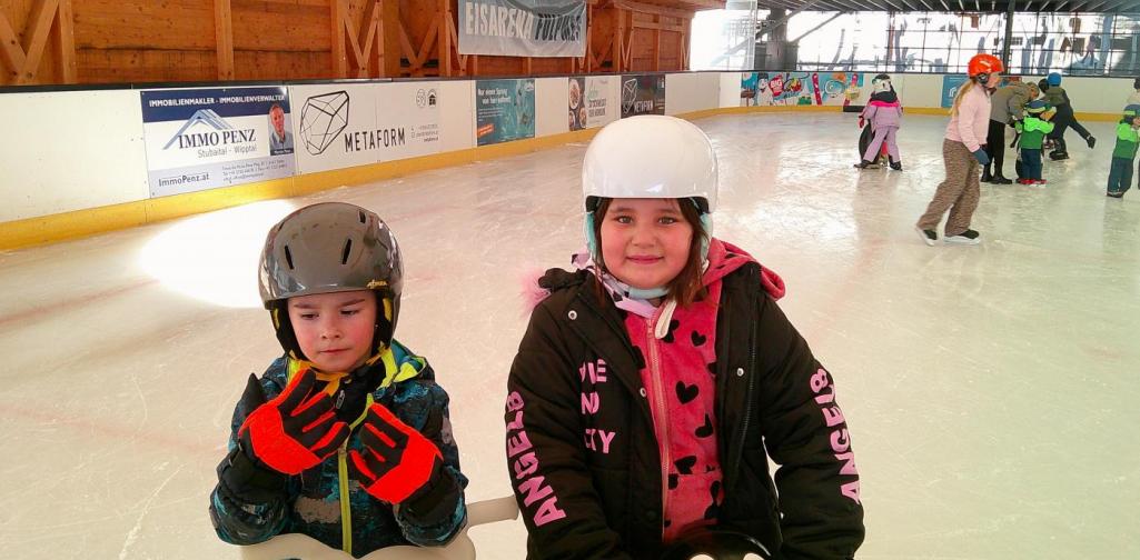 Mädchen und Junge am Eislaufplatz