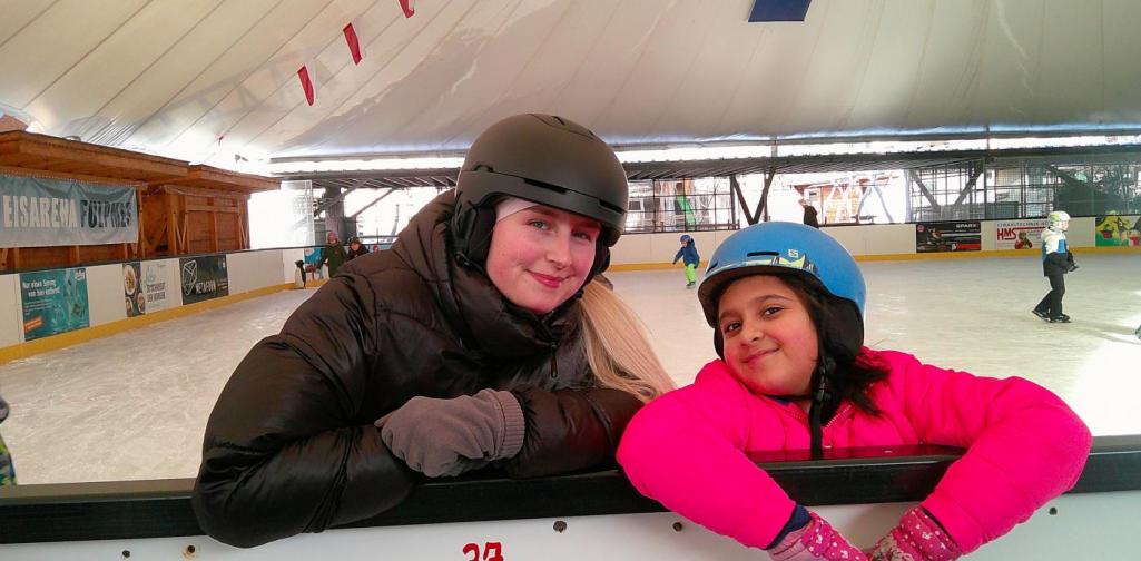 Betreuerin mit Mädchen am Eislaufplatz