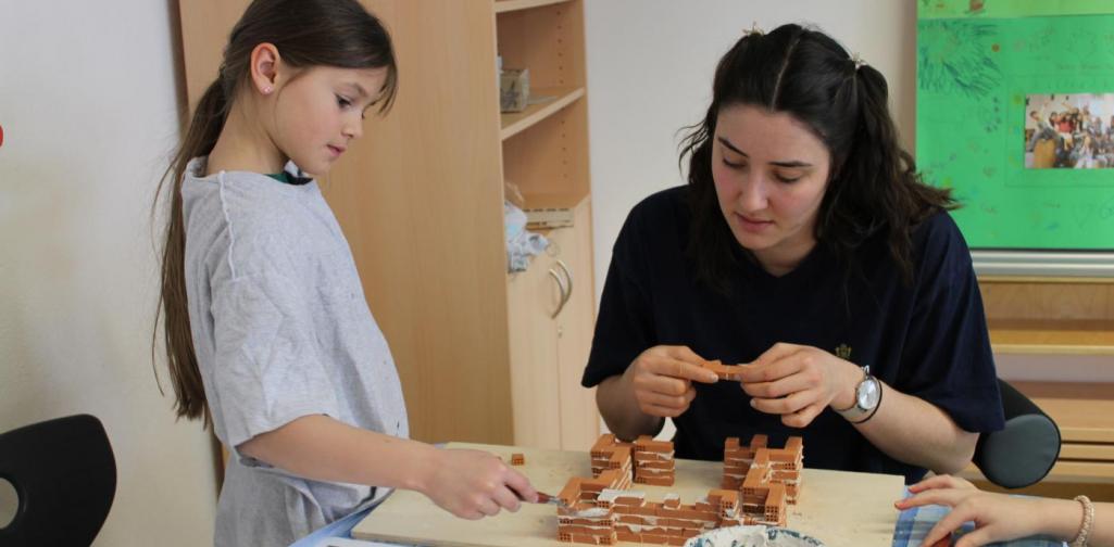 Kind und Betreuerin beim Bauen